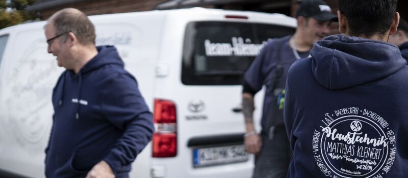 Mitarbeiter vor Firmwagen